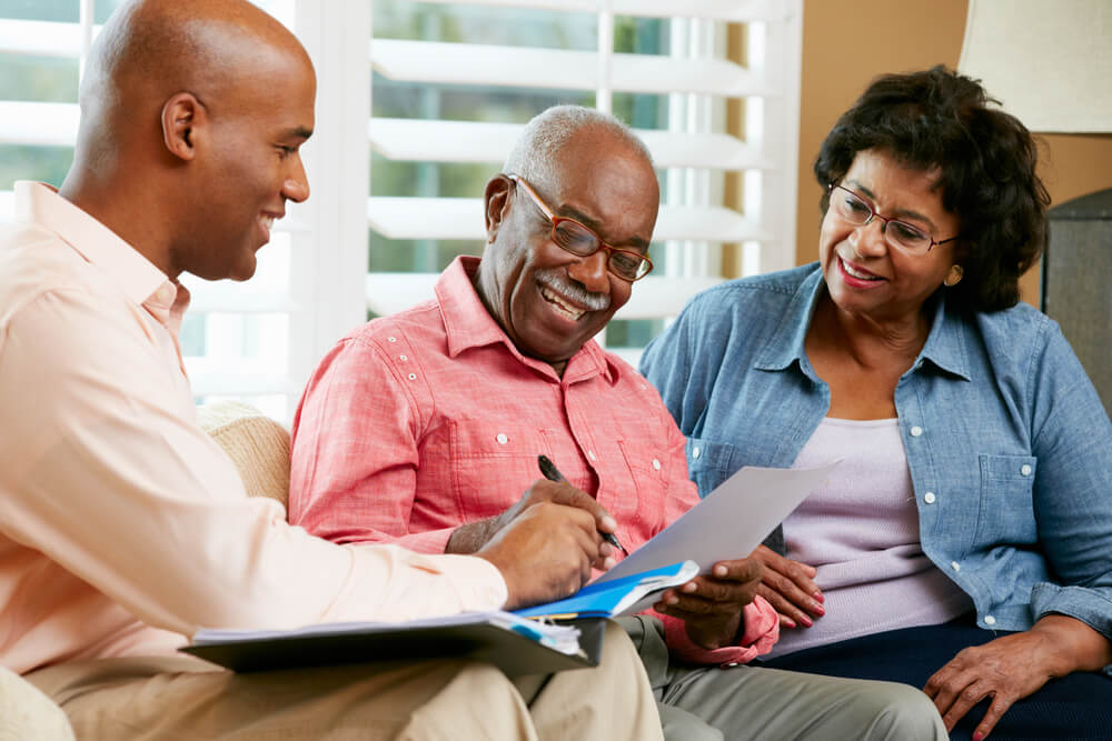 Financial advisor helping a senior couple plan finances for retirement living.